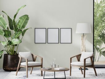 poster frames in room interior with light neutral wall with sunlight and wooden furniture with tropical plant and palm leaves, 3d rendering